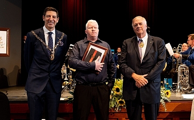 St Bart's volunteer Mark Piggott stands holding an award, with Perth Mayor Basil Zempilas and WA Governor Kim Beazley either side of him